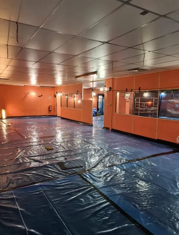 Internal room prepared for safe asbestos removal with floors covered in protective blue plastic sheeting by Stay Safe Environmental.