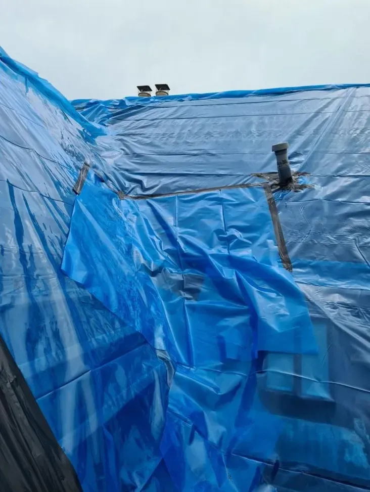Protective blue sheeting covering a roof during asbestos removal