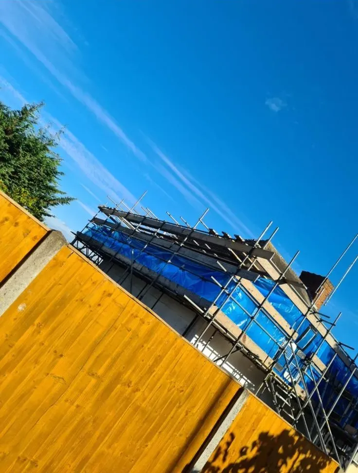 Professional asbestos removal setup with scaffolding and blue tarpaulin on a building in Hampshire.