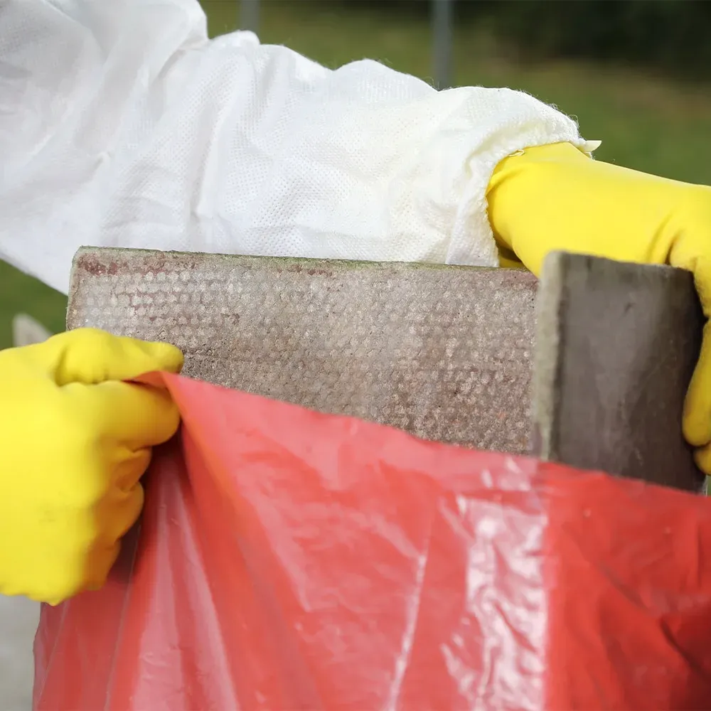 A professional from Stay Safe Environmental safely bagging asbestos waste for disposal in Southampton.